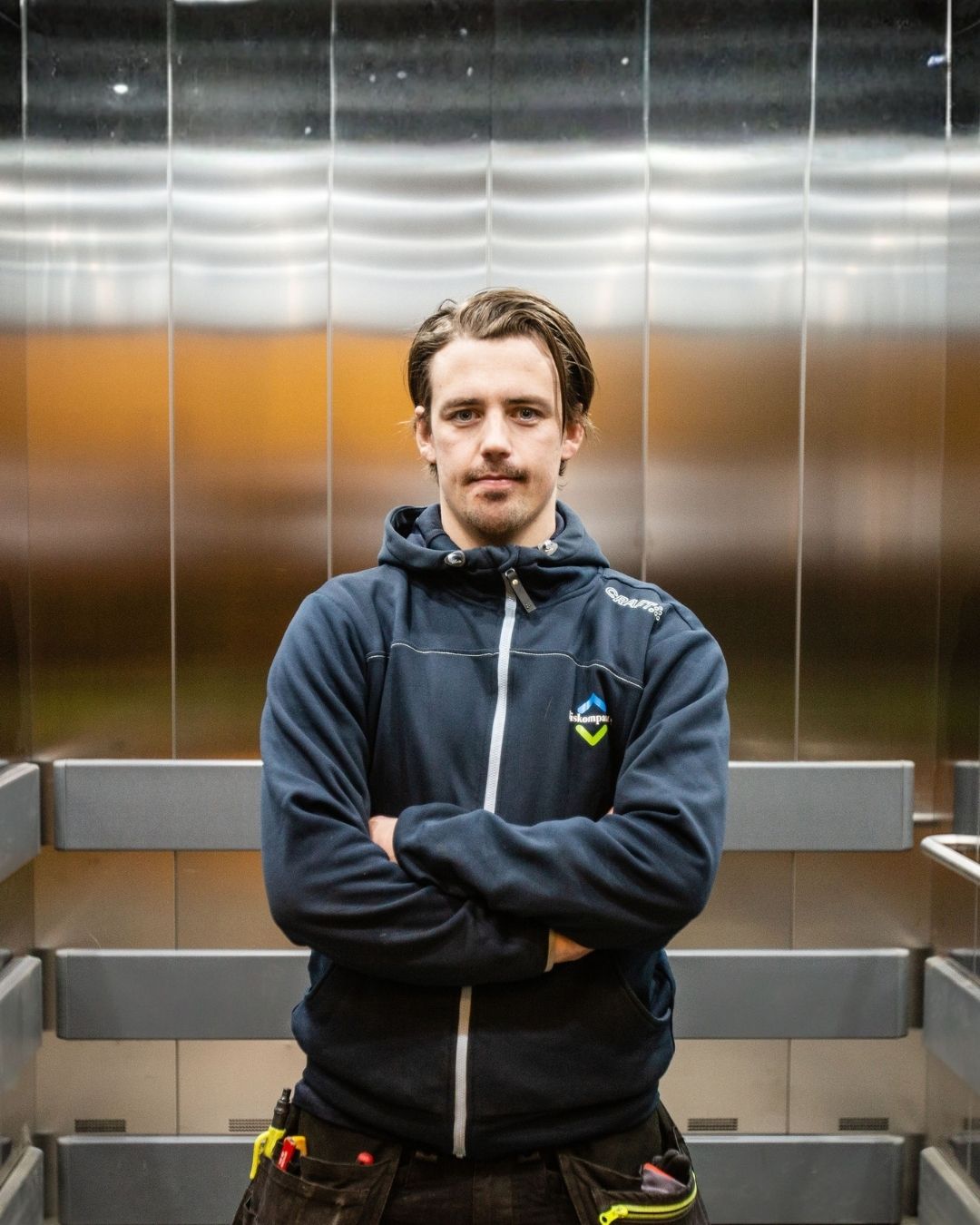 Heismontør fra Heiskompaniet står i en modernisert heis i Oslo-området.